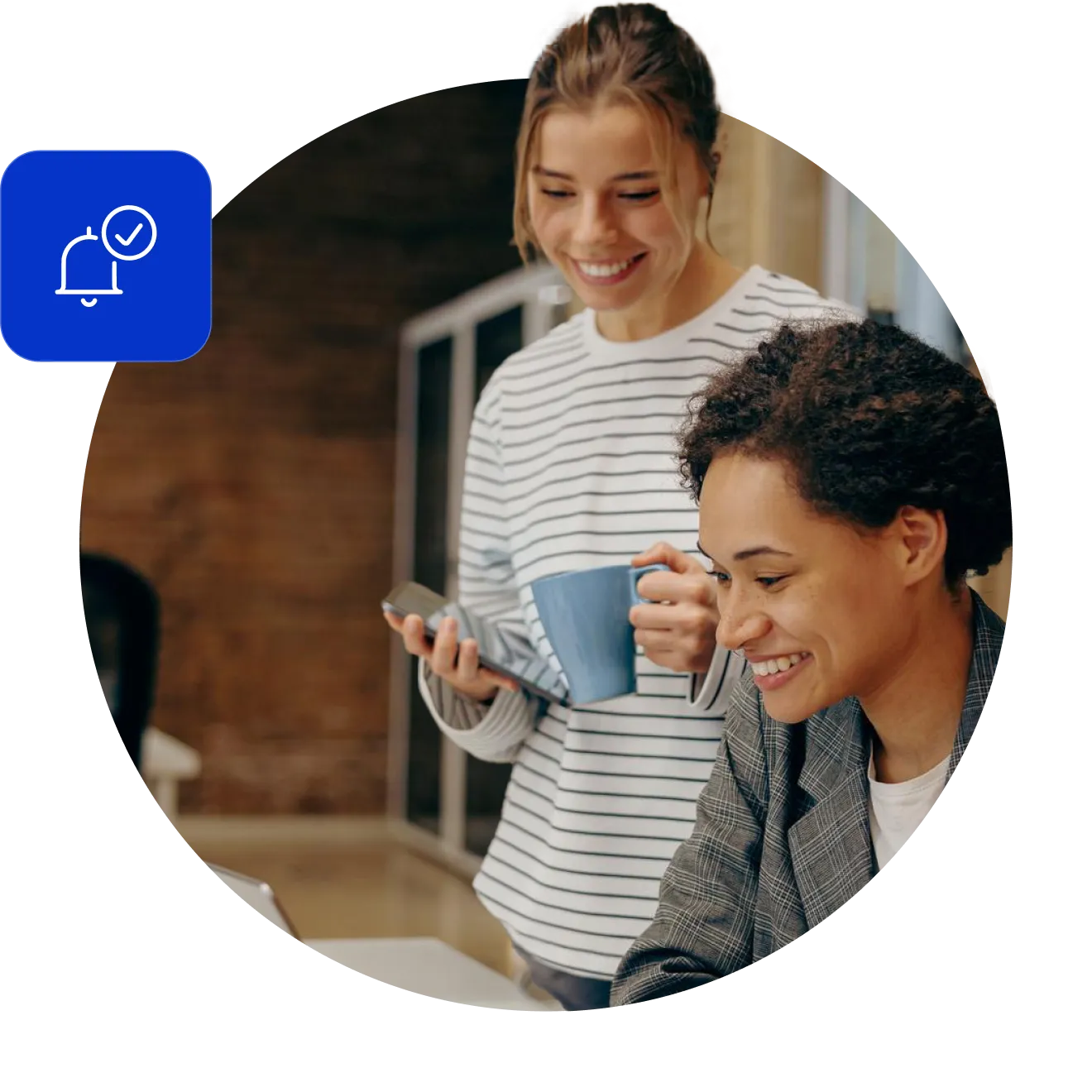 Two smiling colleagues looking at a laptop together, one standing with a phone and a mug of coffee, with a service bell carrying a tick on a blue tile beside them